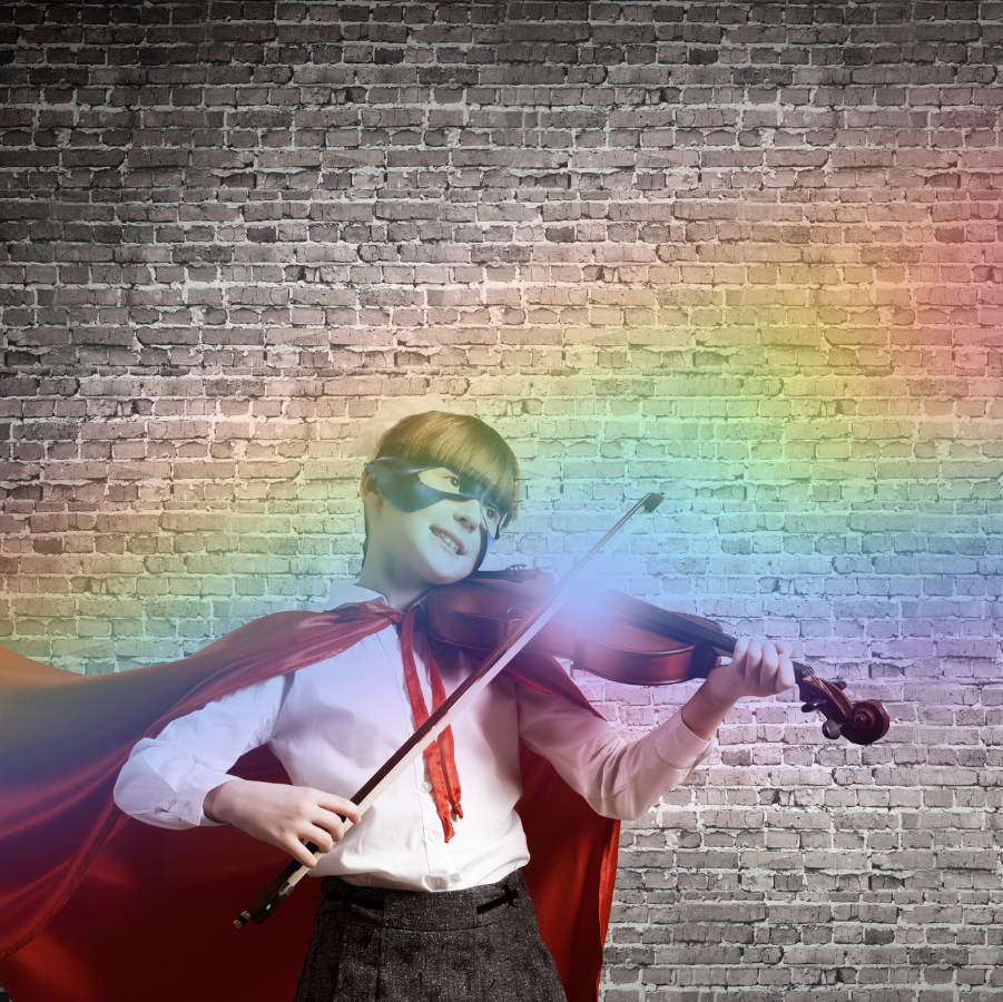 Imaginative child in a superhero mask and cape playing violin and smiling