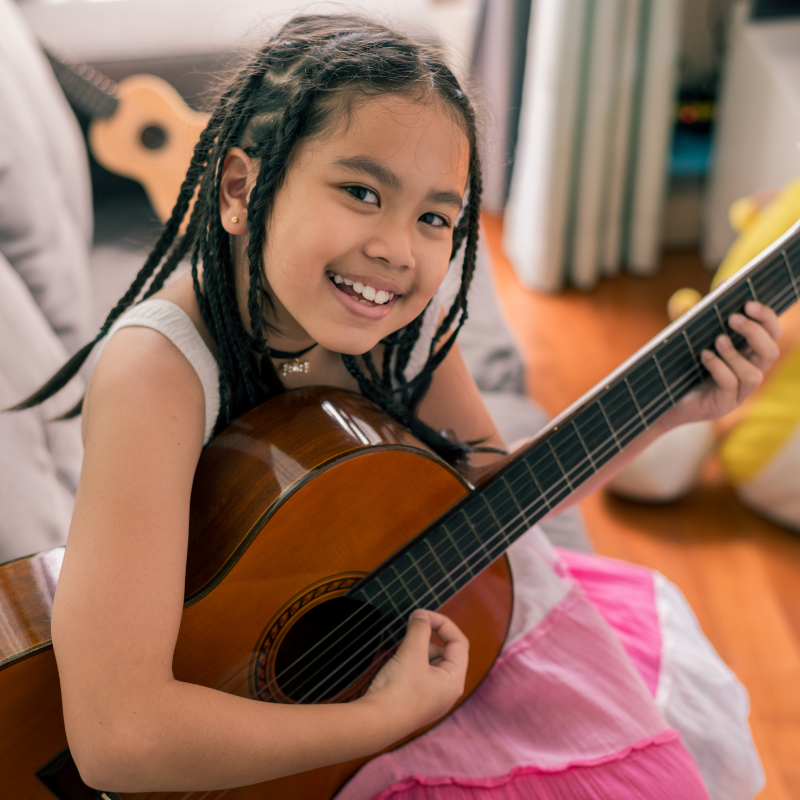 Happy girl playing a guitar