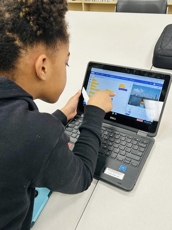 A child programs using  Scratch coding platform on a tablet.